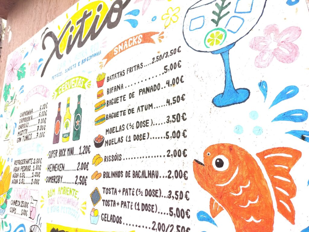 Close-up of the painted menu with a blue cocktail glass, an orange fish and a list of snacks with prices.